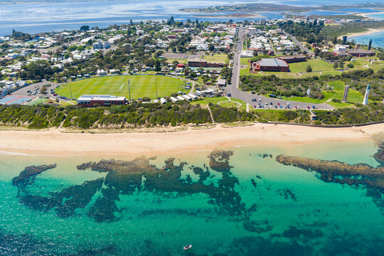 Coastal sports oval and carpark lookout over a sand beach and calm sea