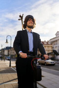 Businessman wearing helmet riding electric scooter urban street