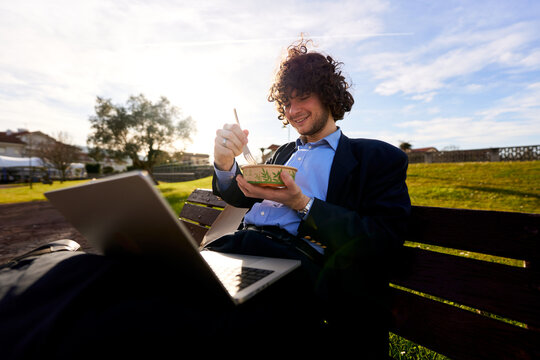 Man working and eating lunch in park