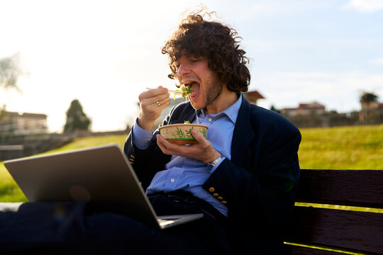 Man eating salad lunch during outdoors work break