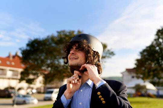 Man fastening helmet strap preparing for urban commute