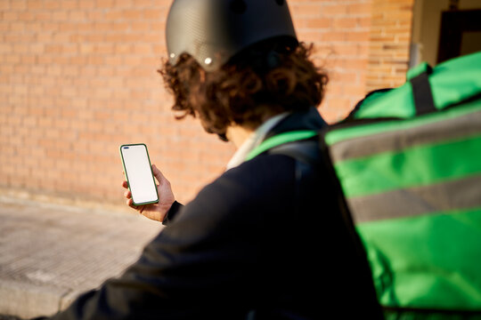 Food delivery rider using smartphone for navigation