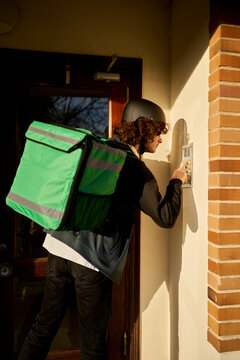 Food delivery rider ringing doorbell delivering takeaway food