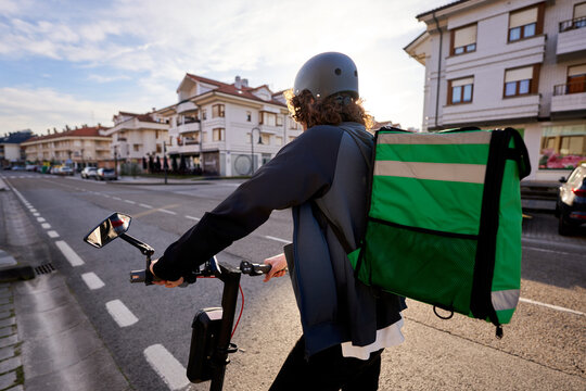 Food delivery rider on e scooter delivering meal