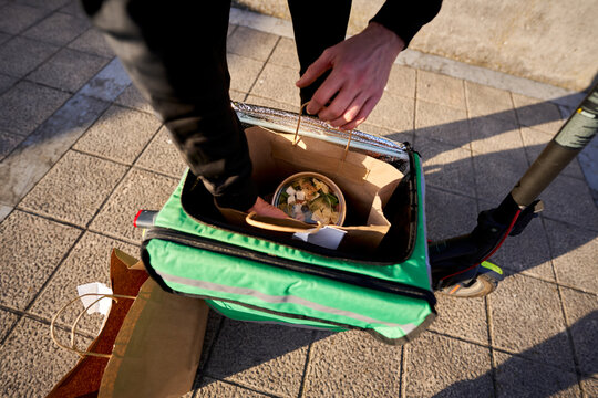 Delivery person checking food order in thermal bag