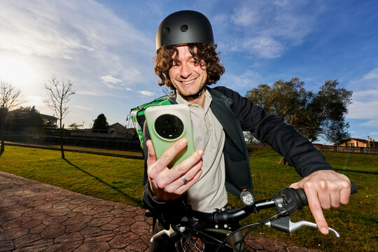 Food delivery rider checking smartphone delivering order