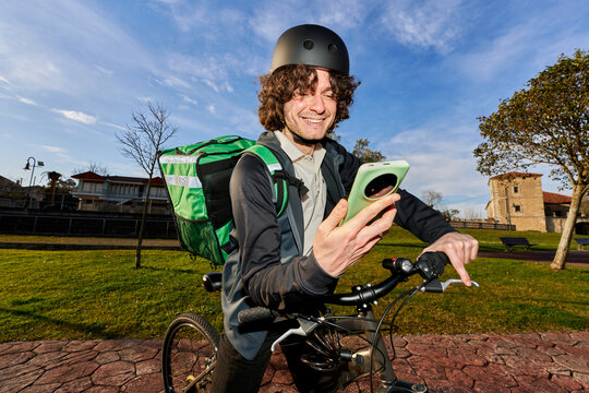 Food delivery rider checking route on smartphone