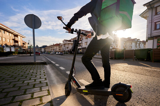 Delivery rider transporting food on electric scooter in city