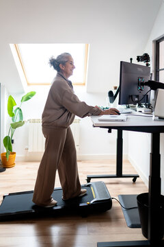 Woman working at standing desk with under desk treadmill