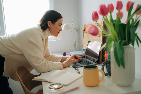 Woman Working on Laptop at Home Desk