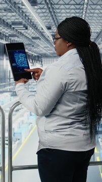 Vertical video Using AI deep learning, EDA software and woman monitoring PCB smart factory workflow. Tracking microchip production, artificial intelligence simulation and African american female