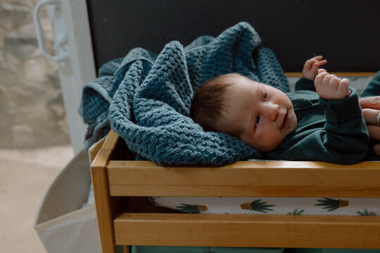 Newborn baby lying on changing table with blue blanket