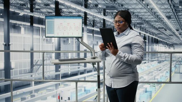 Portrait of smiling woman reviewing semiconductors smart factory schematics. Cheerful african american businesswoman oversees infrastructure layouts using EDA software in industry 4.0 plant, camera A