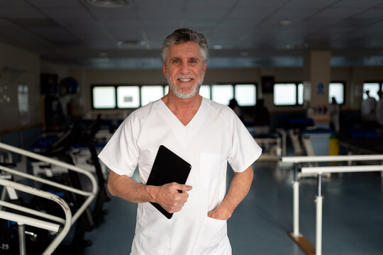 Senior physiotherapist holding tablet in clinic