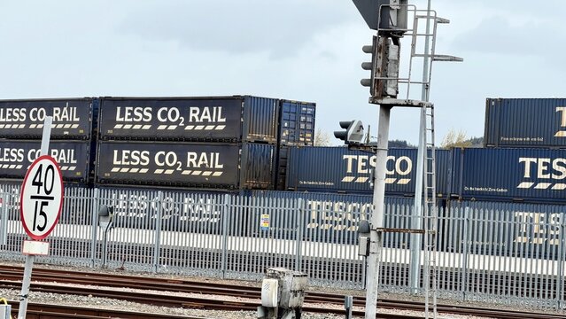 Tesco Net Zero eco-friendly UK distribution of goods by rail to the Highlands to prevent over use of HGV's showing several branded shipping containers in a rail yard in Inverness. 