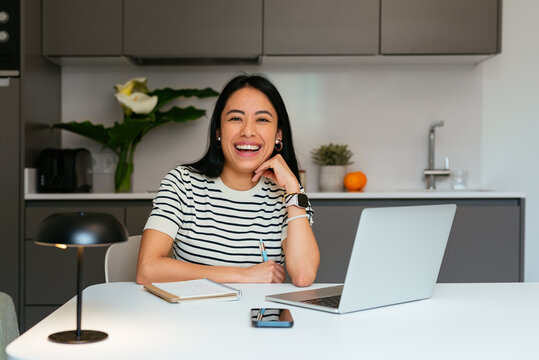 Smiling Young Businesswoman Working from Home with Laptop