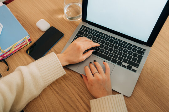 Top view of female hands typing on laptop keyboard