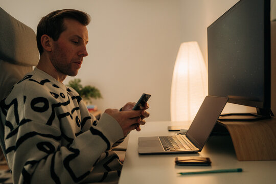Man Checking Phone at Desk During Work Hours