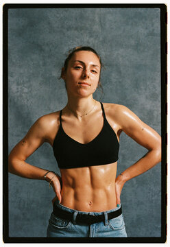 Fitness model poses confidently in studio setting