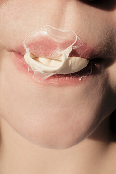 Person chewing gum with bubble on lips in bright light