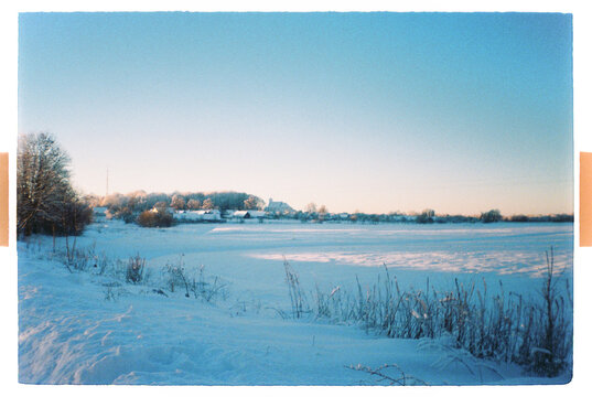 Frozen Lake Covered in Snow Under Clear Winter Sky