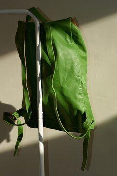 Bright green backpack hanging on a rail