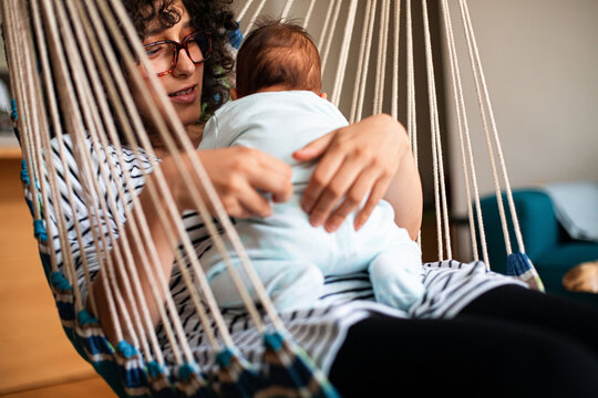 Mother Holding Baby in Indoor Hammock Chair