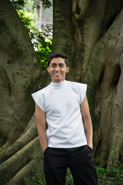 Person Stands by Large Tree in Outdoor Setting During Daytime