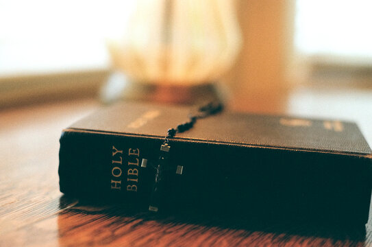 Close-Up of Bible and Rosary Beads with Crucifix on Table