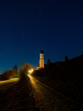 Church Tower Illuminated at Night on Starry Hill