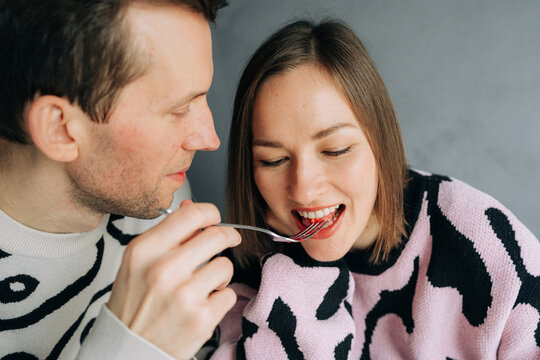 Romantic Couple Sharing Cake in Cozy Indoor Setting