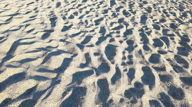 Sandy beach with many footprints in the sand