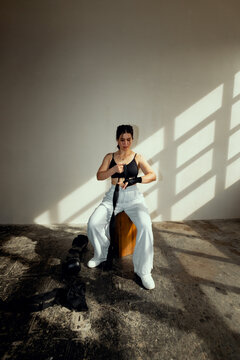Athlete sitting on a gym box, securing hand wraps before boxing.