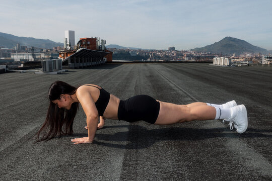 Female athlete performing a push-up during outdoor training.