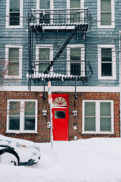 Red Door on Brick Building with Snow and Fire Escape
