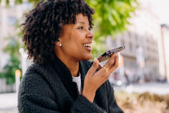 A woman recording a voice message on a mobile phone