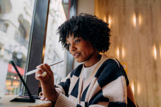 A woman using a tablet in a cafe
