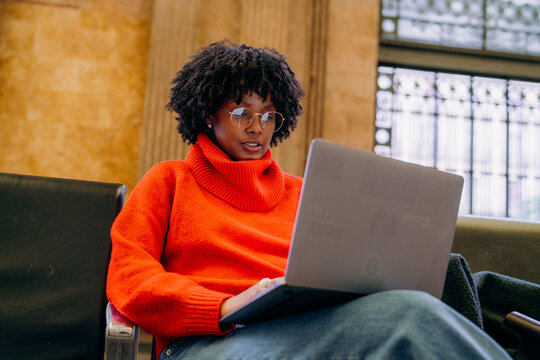 A woman uses a laptop in the waiting room