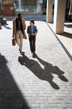 Business people walk together on city sidewalk