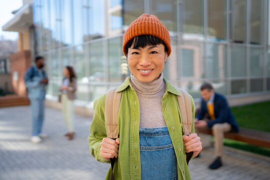 Person smiling in urban setting with backpack