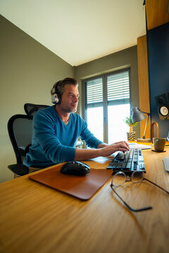 Man at home desk with headphones