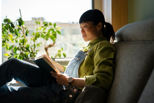 Reading a book by the window during the day