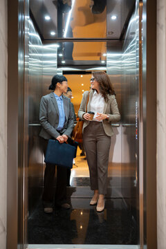 Two women traveling in an elevator at work