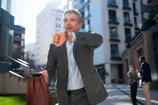 Businessman rushing down city street with bag