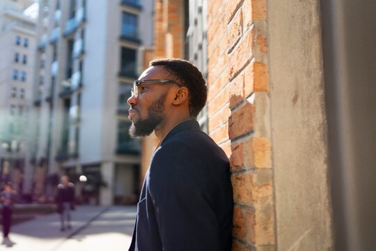Man leaning against wall in city during daytime
