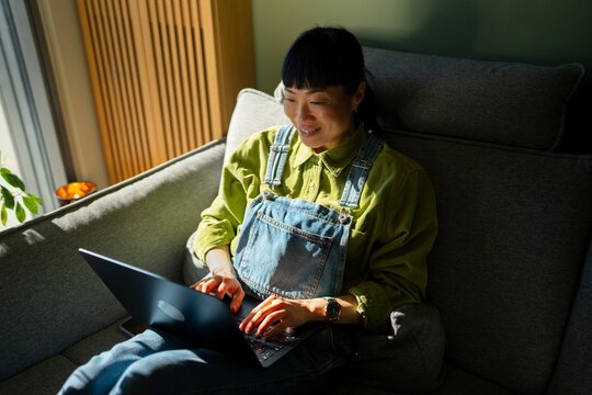 On couch, laptop in the sun
