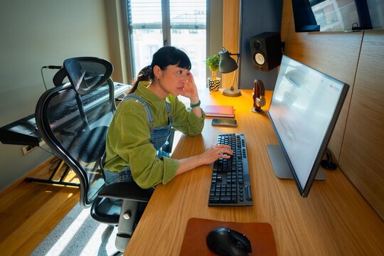 Woman working at a desk with computer in a room