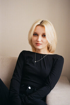 Young Woman in Black Top and Jeans on Sofa, Film Portrait