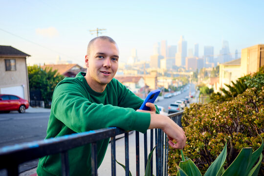 Man smiles while standing on the street in suburban LA