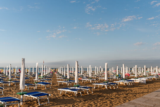 Sandy Italian beach off season. Empty seashore with closed sunshades.